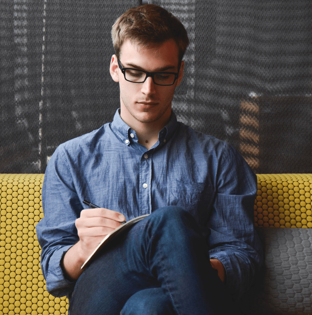 Man sat on the sofa designing a mobile app