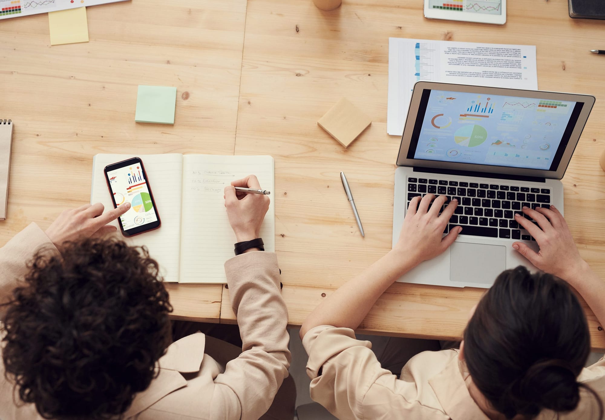 Two people sat a desk automating tasks with their bespoke business work flow app